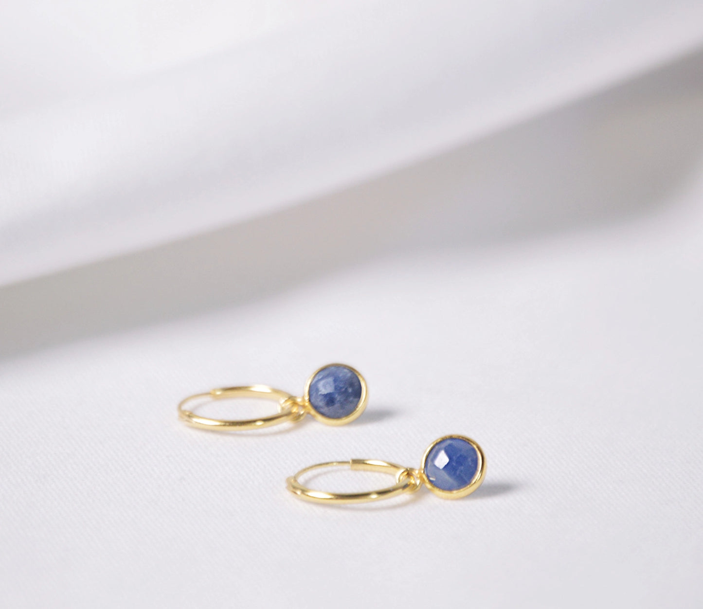 Thin gold hoop earrings with blue sapphire