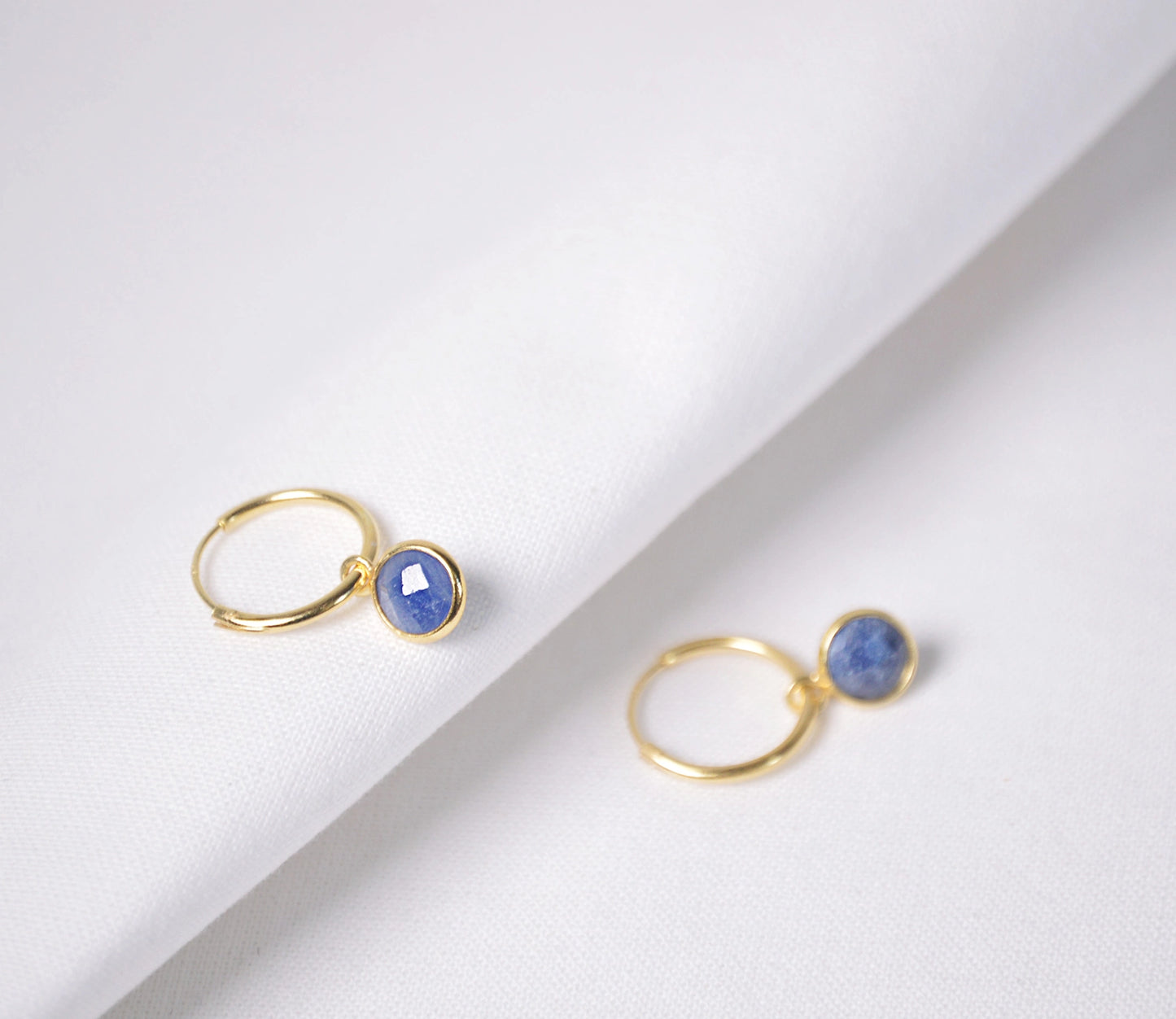 Thin gold hoop earrings with blue sapphire